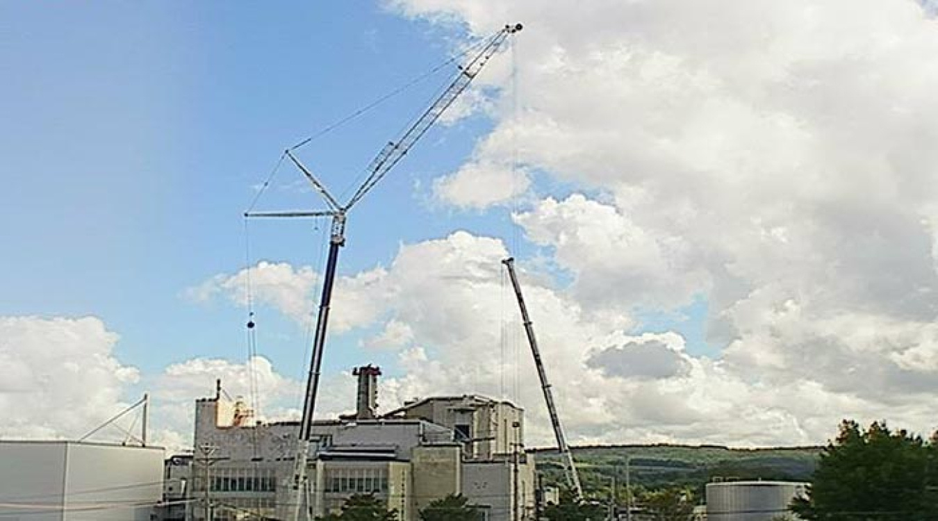 A crane lowers the ventilation stack to the ground.