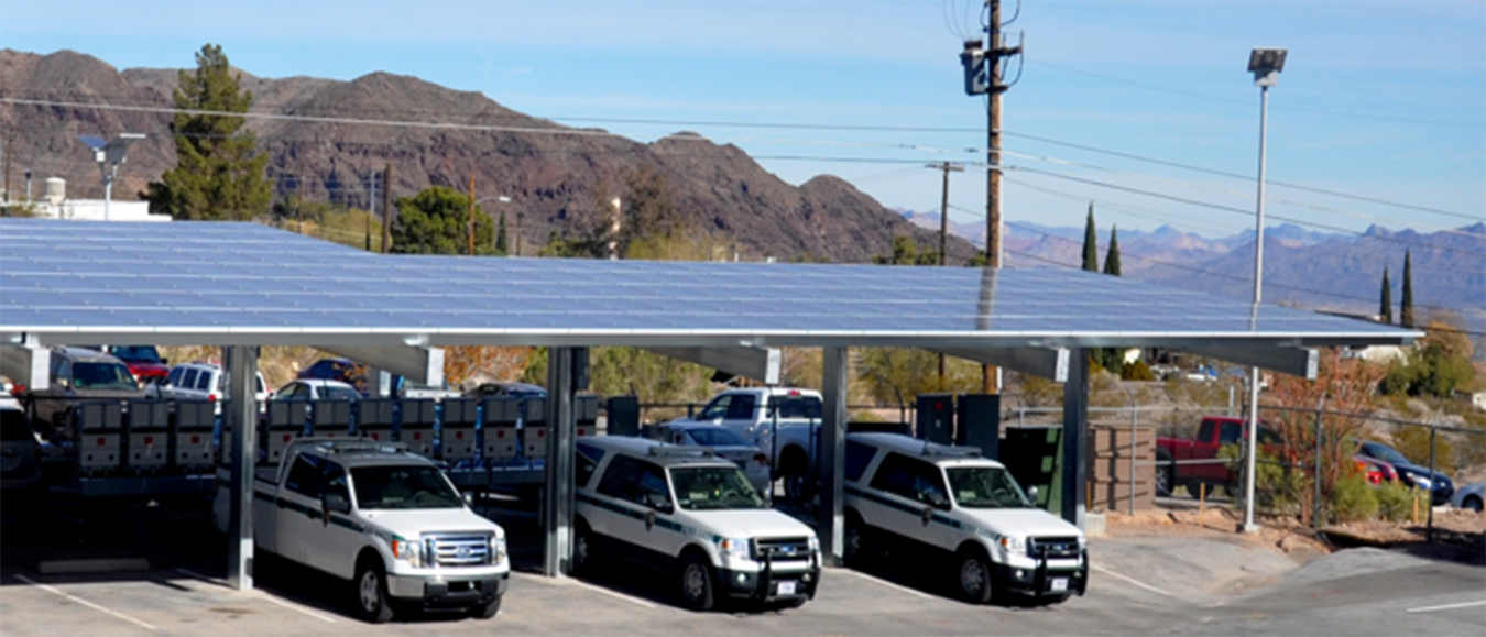 Cars parked under a roof of solar panels.