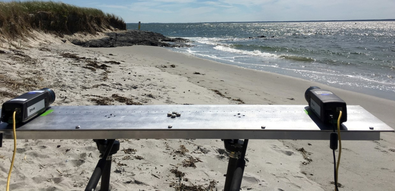 Photo of a table set up on a beach with two cameras on it.
