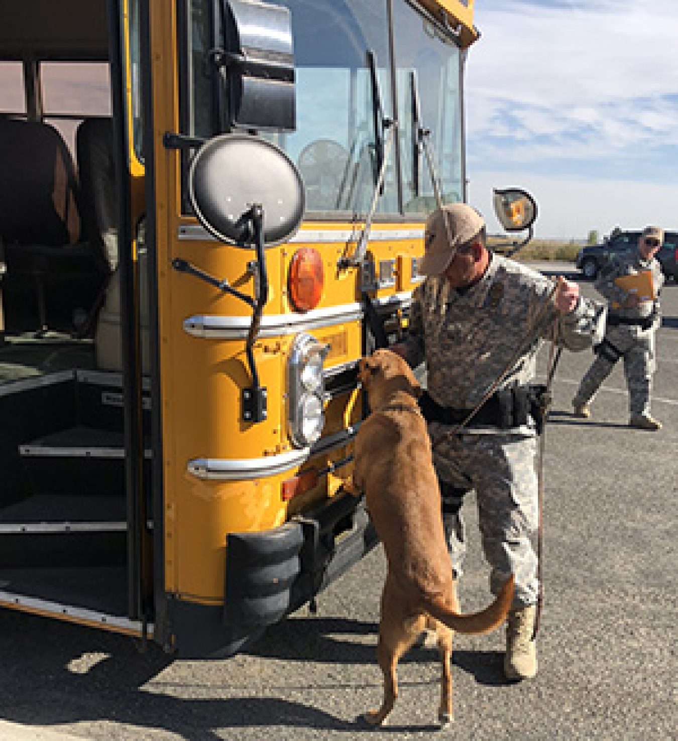 Hanford Site patrolman and master handler Ed Pacheco runs his canine partner Chance through a series of searches on a bus used for training purposes.