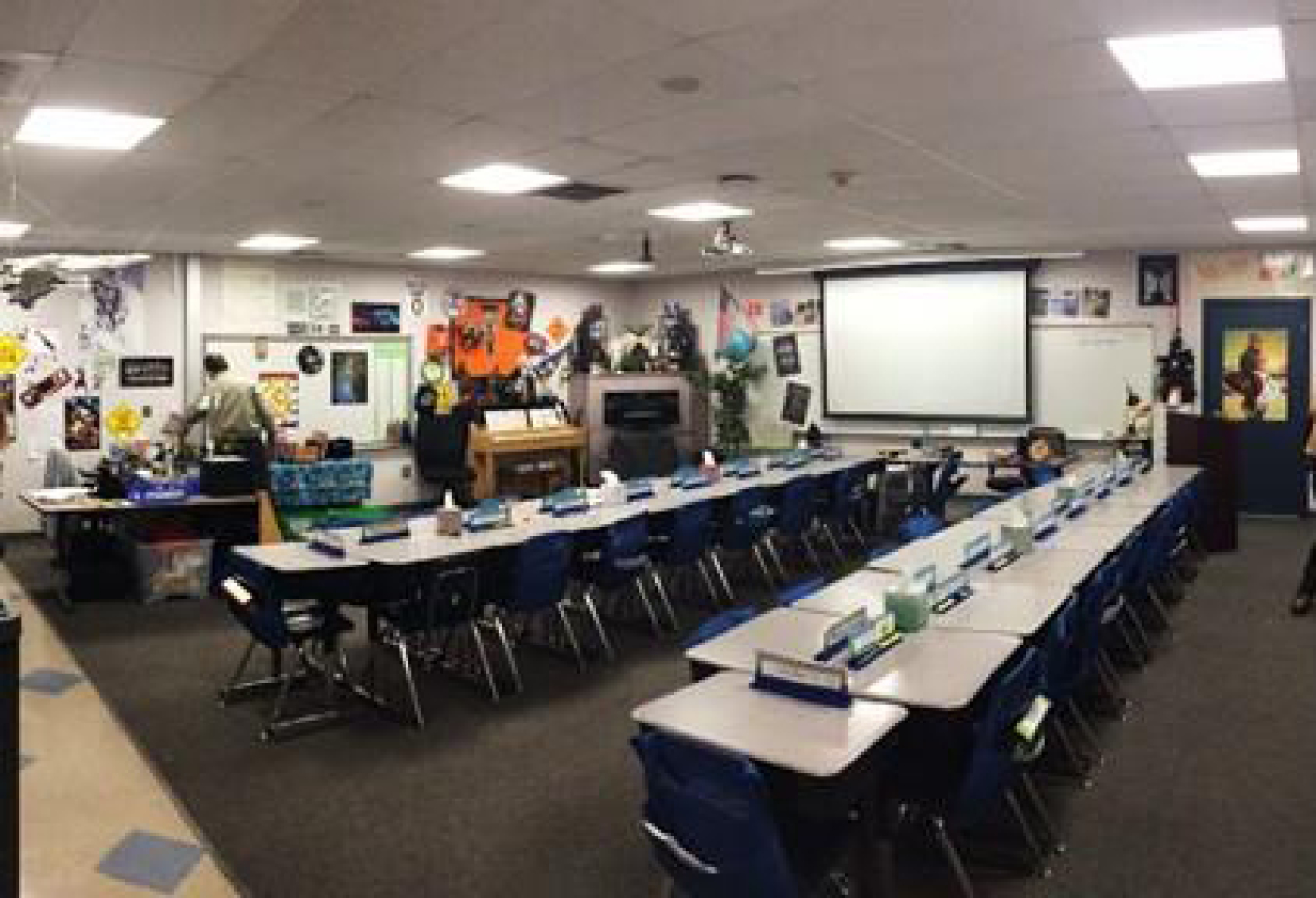 A photo of a classroom with desk and chair, and overhead lighting.