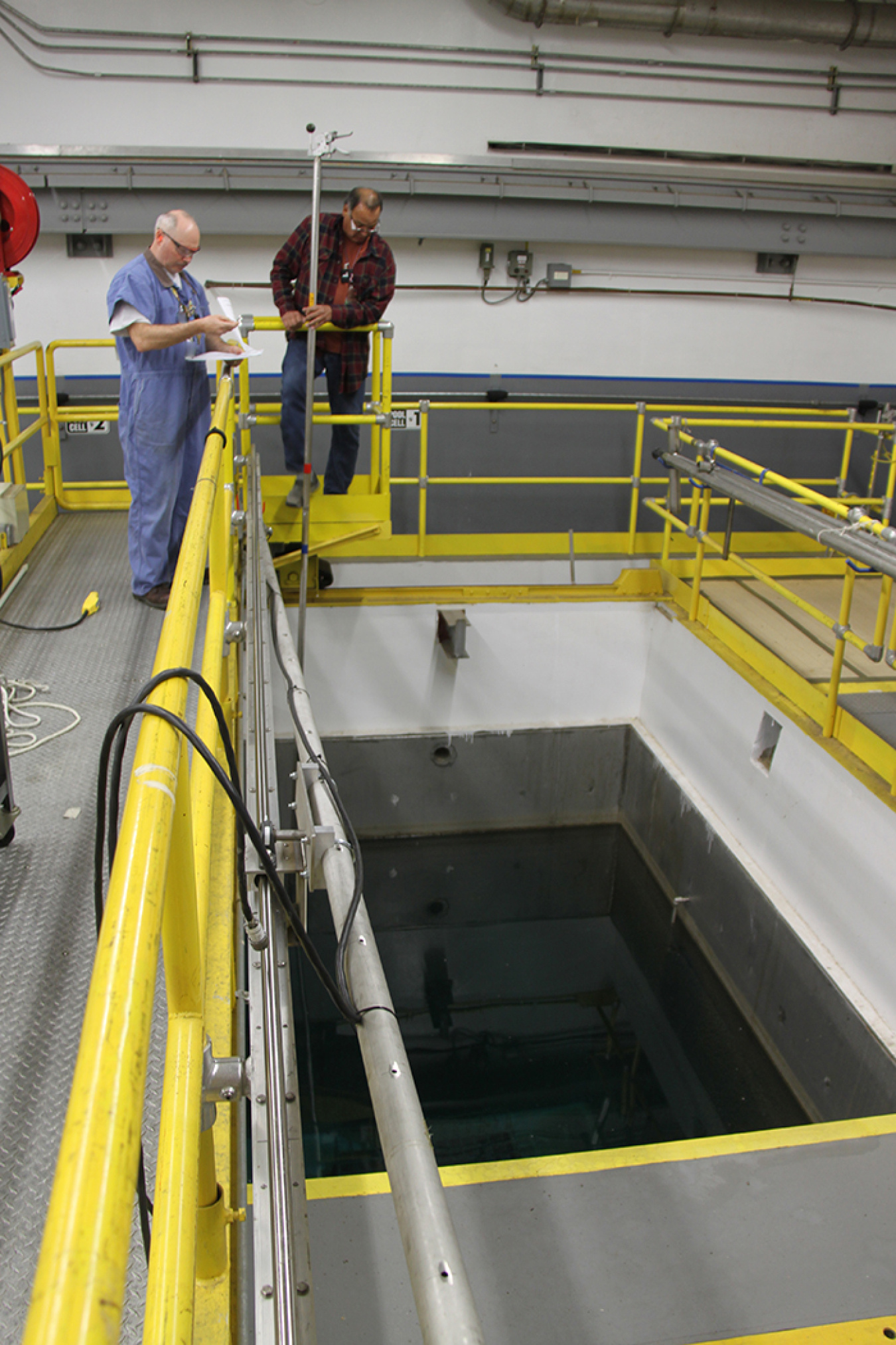 Workers at the Waste Encapsulation and Storage Facility using long-reach tools to verify the 1,936 cesium and strontium capsules meet the design criteria