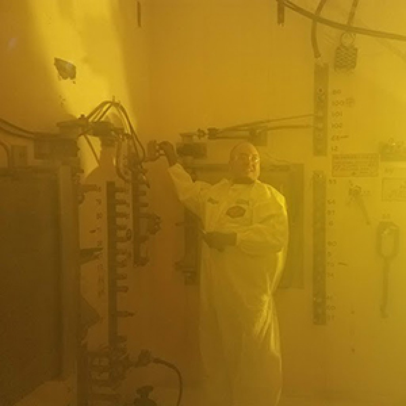 A Waste Encapsulation and Storage Facility (WESF) worker installing cooler and brighter lights inside a hot cell.