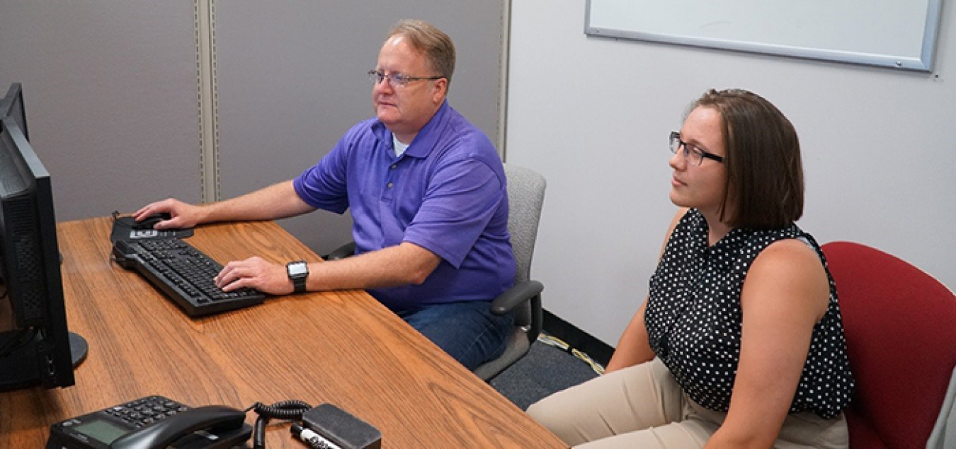 Savannah River Remediation Principal Cyber Specialist Sean Nixon, left, mentors high school student Colleen Harmon on cybersecurity applications.