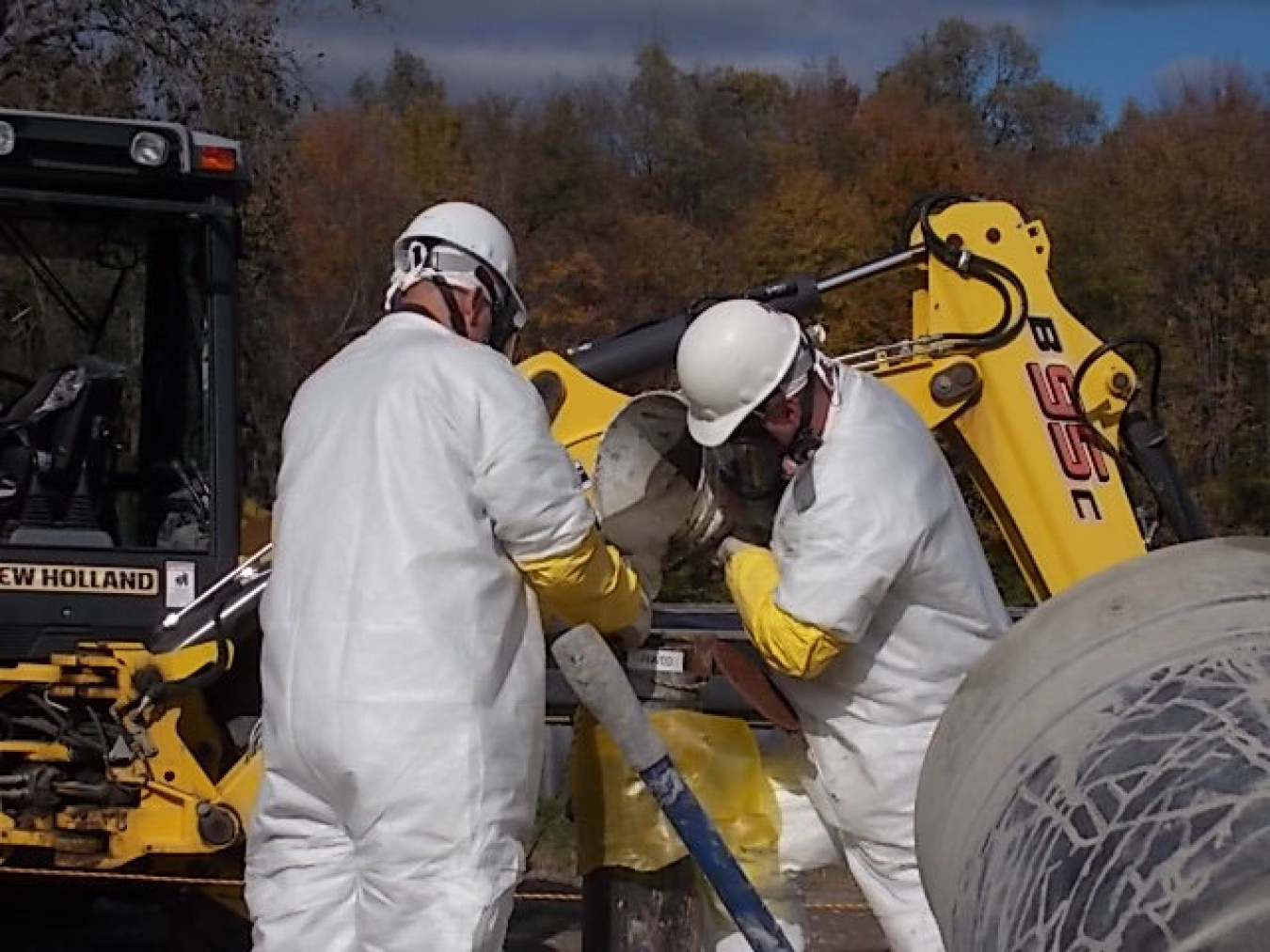 Crews pour grout into the well pump casing to stabilize it before pulling out the well pump.