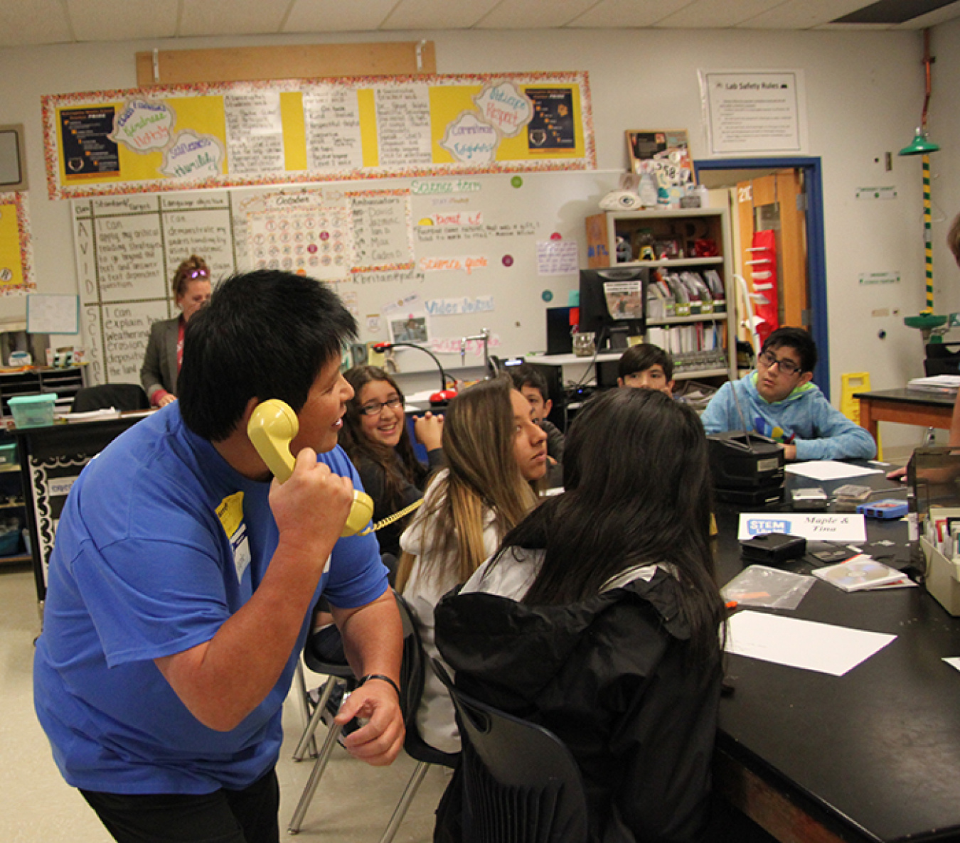 CH2M HILL Plateau Remediation Company mentor Maple Lee demonstrates the limits of a rotary corded phone during a “Technology Over Time” module.