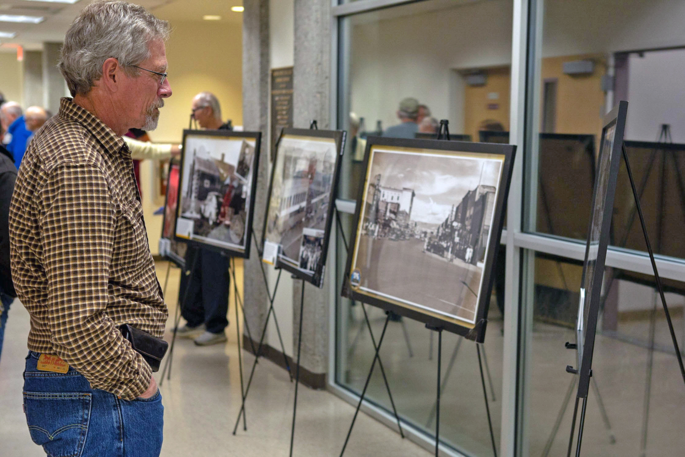 Attendee reads the interpretive information on one of the display’s historic photos.