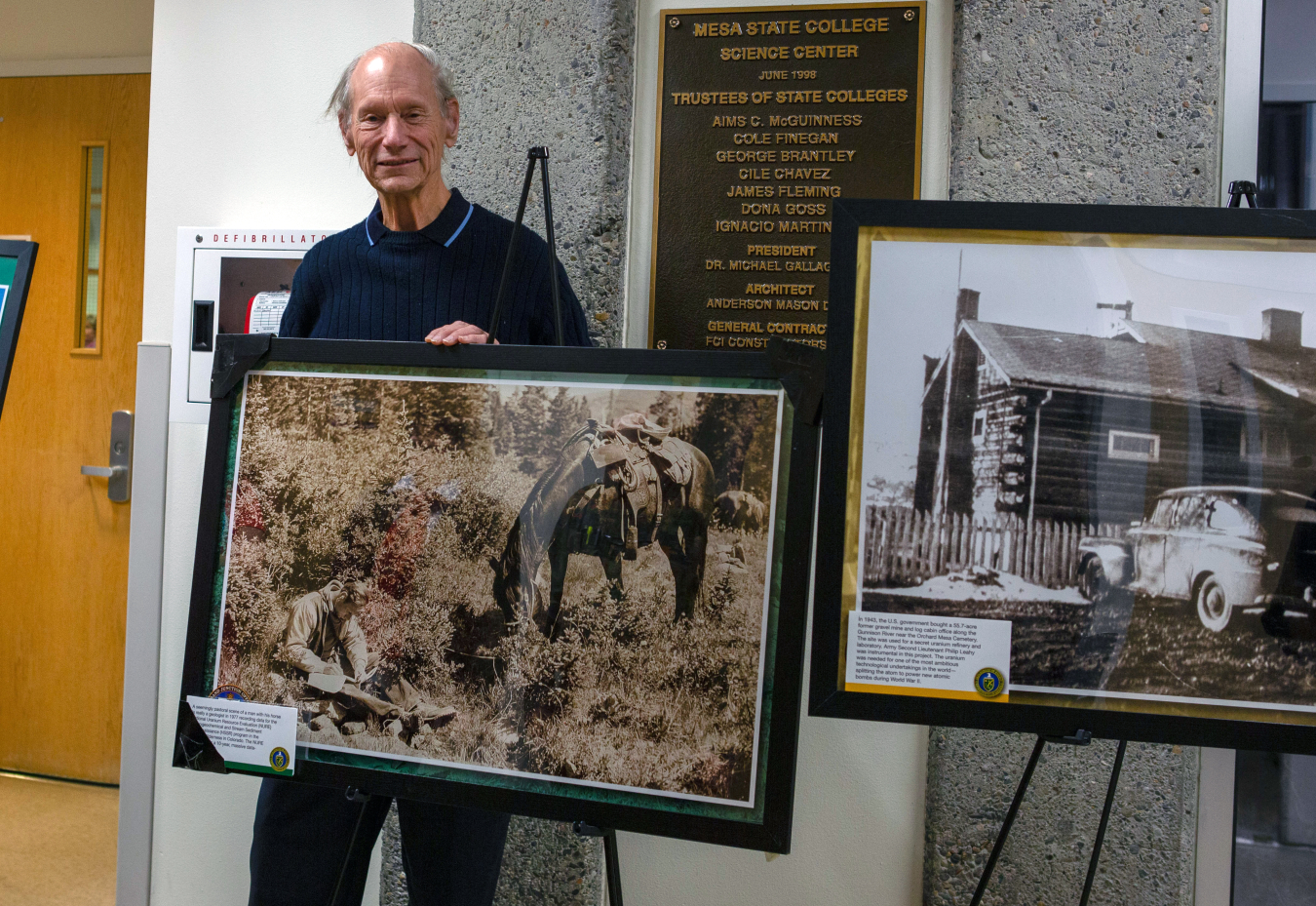 A former DOE geologist poses with his photo, which was taken in 1977.