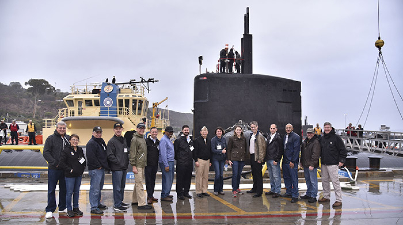 EM Assistant Secretary Anne White, seventh from right, gathers with others waiting to board the USS Pasadena in San Diego.