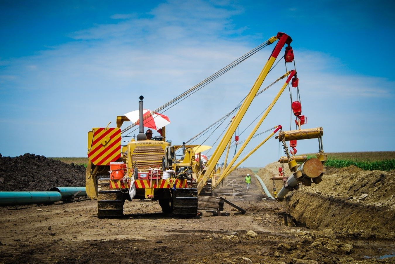 An equipment operator installing a segment of pipeline