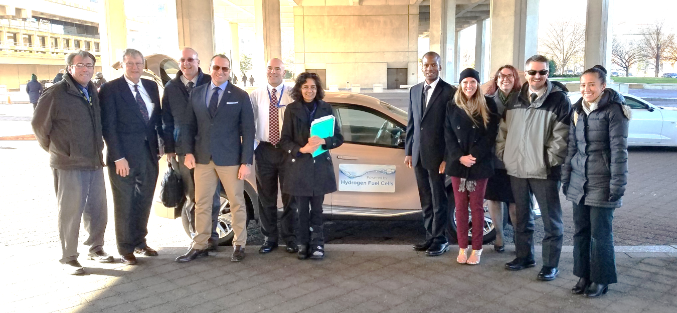 People standing in front of a hydrogen fuel cell vehicle.