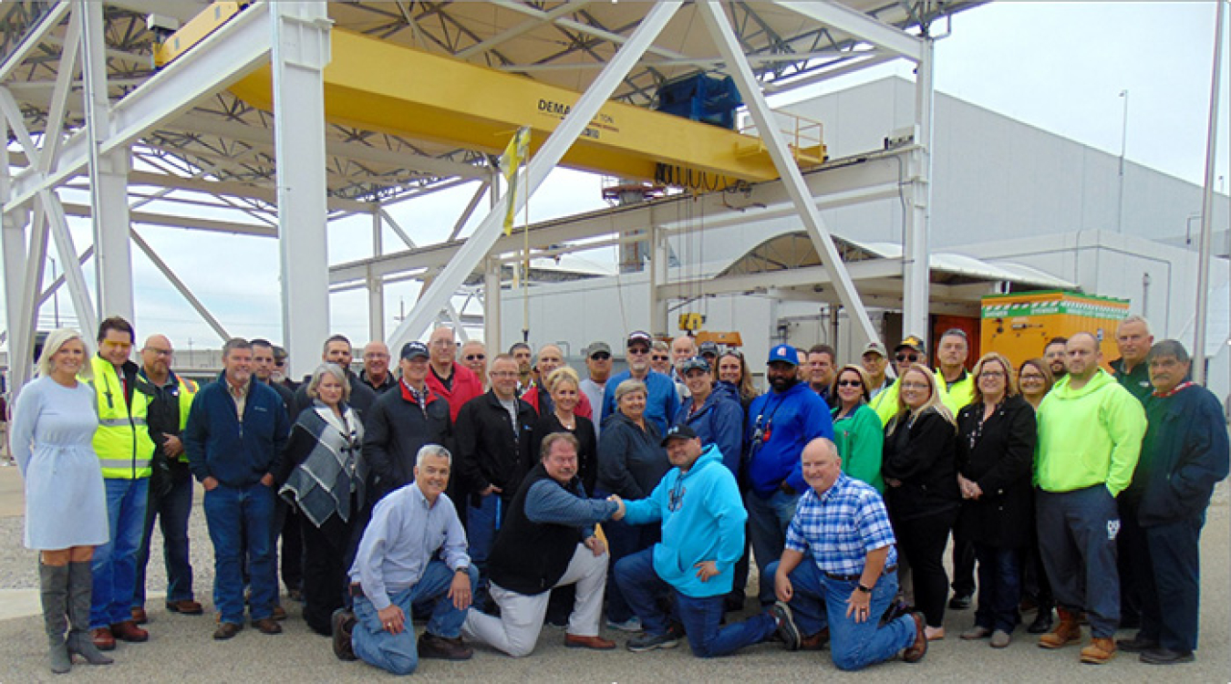 PPPO Manager Robert Edwards, shaking hands with Mid-America Conversion Services Union Safety Representative Jeremy Bates & personnel at EM’s Portsmouth Site for a group photo to commemorate all seven DUF6 Conversion Project production lines in operation.