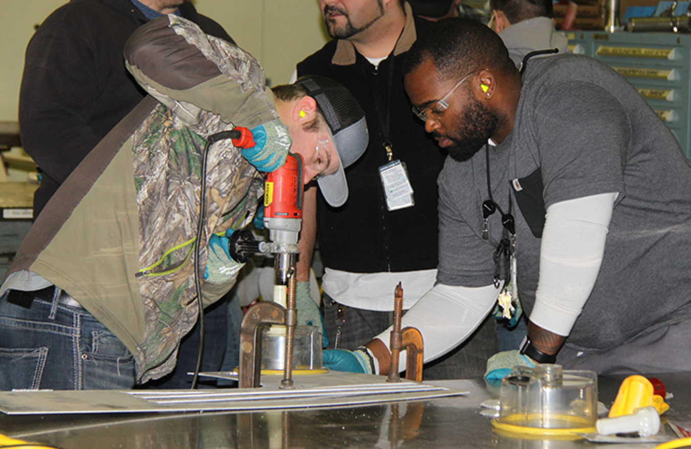 Justin Weathers, right, an employee with EM Richland Operations Office contractor CH2M HILL Plateau Remediation Company (CHPRC), instructs a new hire on the use of a specialized drill system.