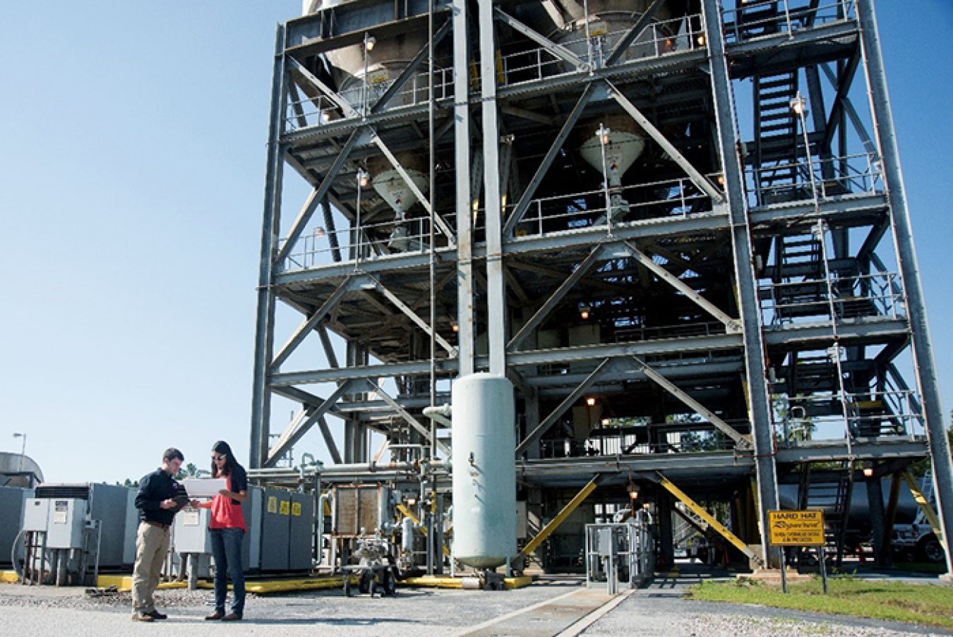 Savannah River Remediation engineers work in front of the silos at the Saltstone Production Facility, where decontaminated salt solution is mixed with a cement-like grout for safe and permanent storage in the EM's Saltstone Disposal Units.