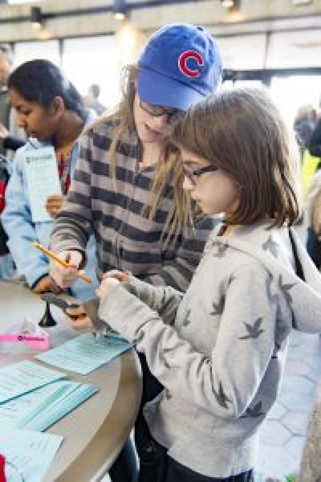 Children work together to find the center of mass of various objects. 