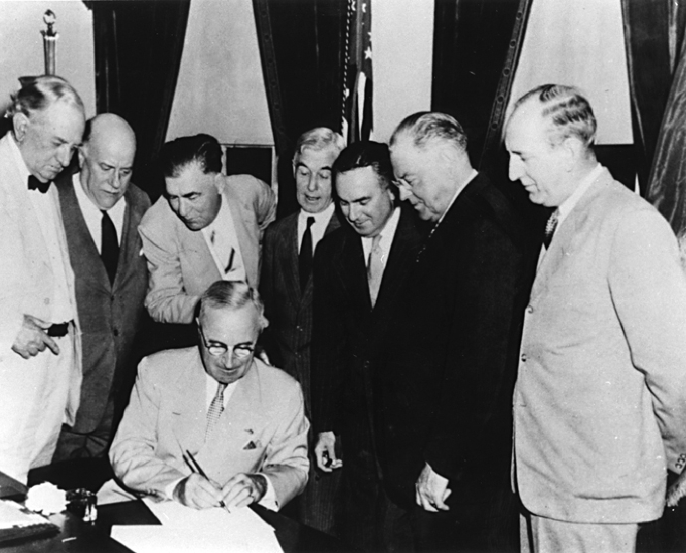 President Harry S Truman signs the Atomic Energy Act of 1946 establishing the U.S. Atomic Energy Commission.