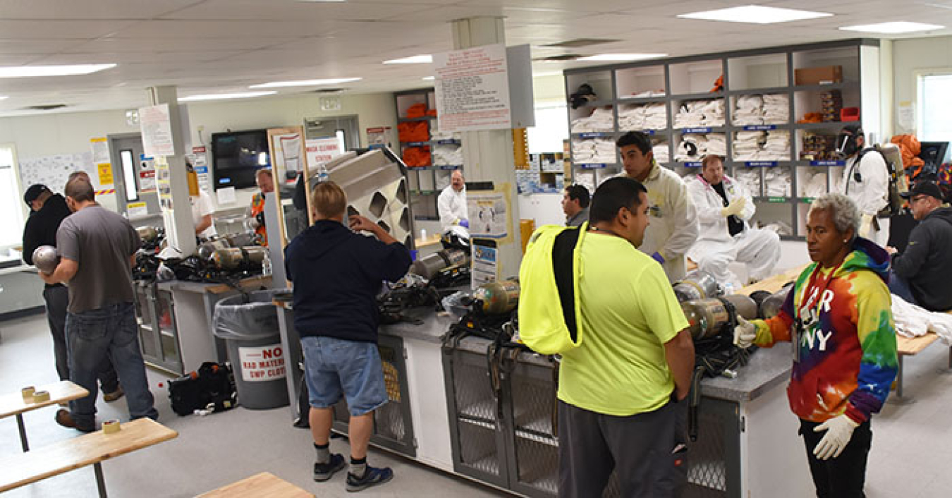 A change trailer at Hanford’s tank farm buzzes with activity as employees don or doff personal protective equipment. The facility recently underwent improvements to increase safety and efficiency for employees.