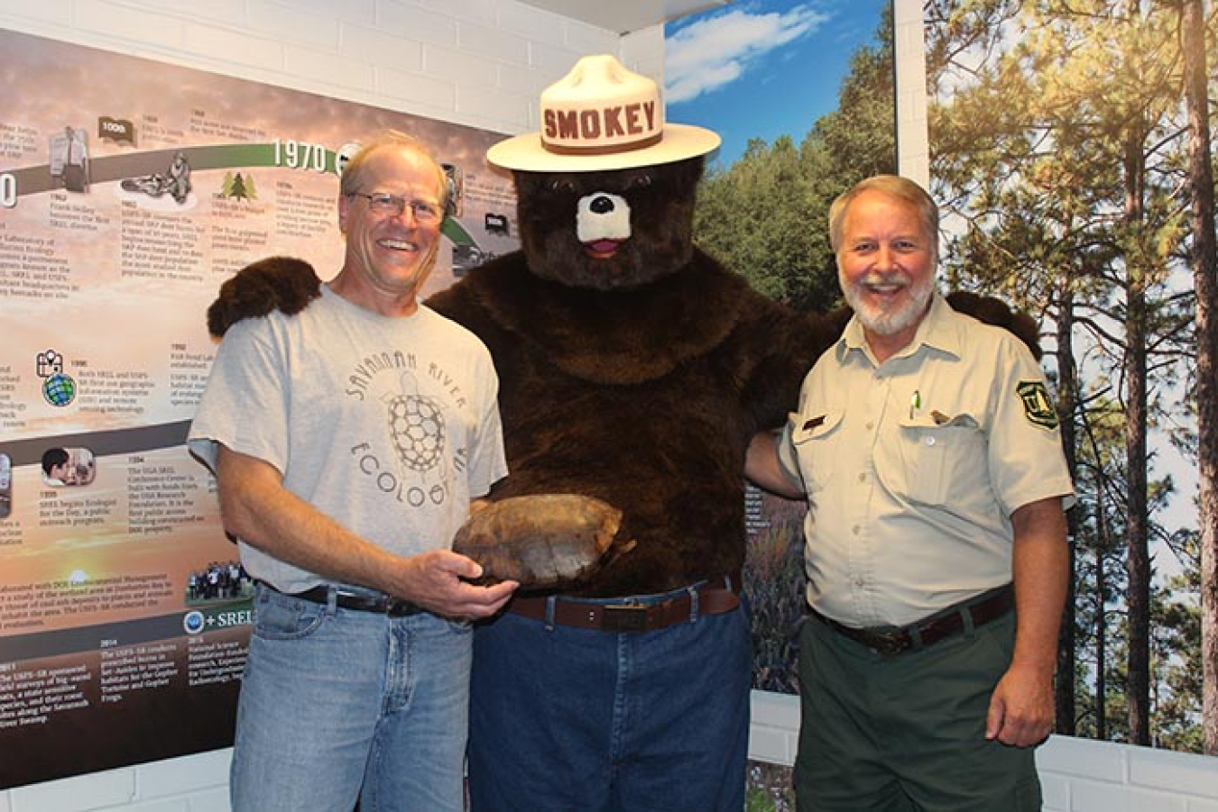 From left, Kurt Buhlmann, senior research associate at Savannah River Ecology Laboratory, holding a gopher tortoise shell, and Charlie Davis, forest ecologist with the U.S. Forest Service-Savannah River, pose with Smokey Bear.