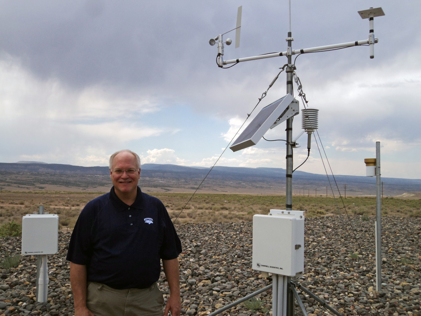 DOE Site Manager Rich Bush explains the Enhanced Cover Assessment Project to Colorado Mesa University students while standing next to one of LM’s Systems Operation and Analysis at Remote Sites locations, which collects data remotely and transmits it to LM