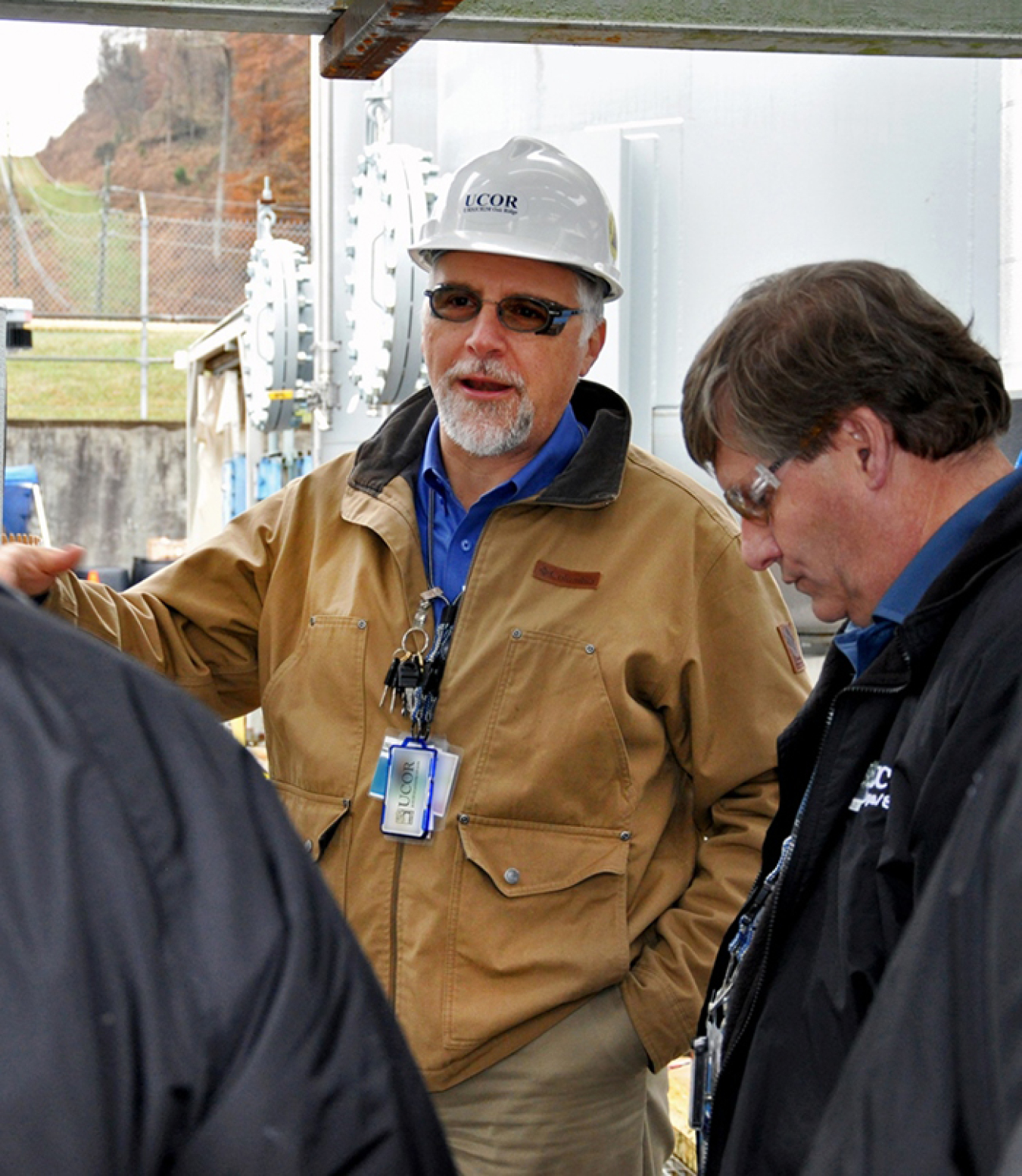 UCOR President and CEO Ken Rueter talks with UCOR employees at a project site, including Liquid Gaseous Waste Operations Project Manager Charles Curtis.