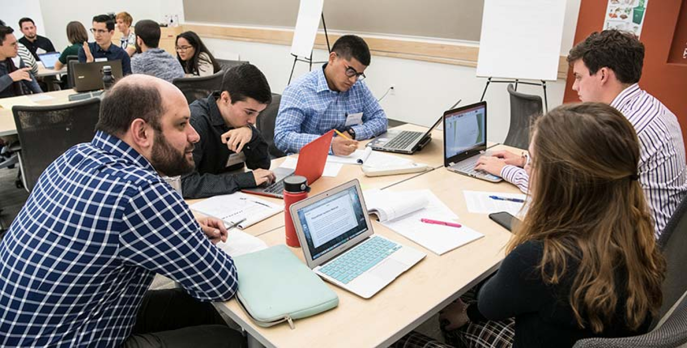 NREL engineer Tony Fontanini mentors a group of students working on the mini-hackathon challenge.