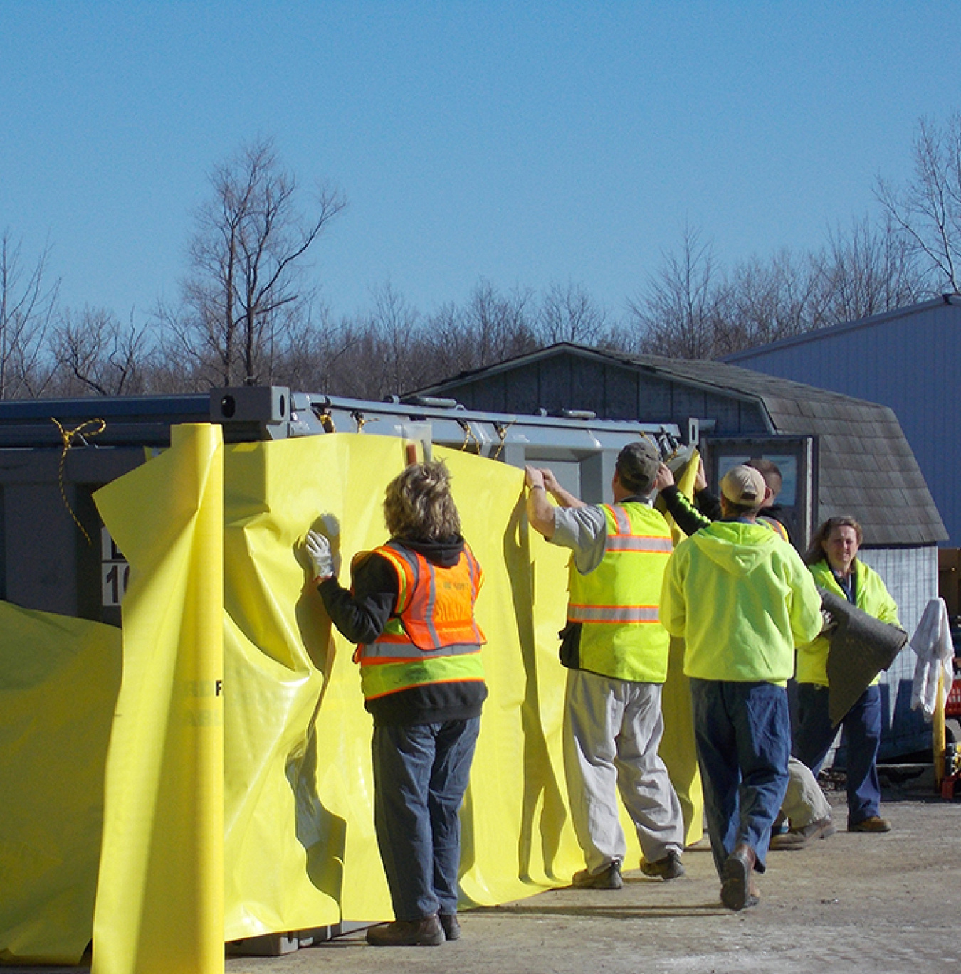 A CH2M HILL BWXT West Valley waste operations crew prepares a waste container for debris from the Vitrification Facility demolition.