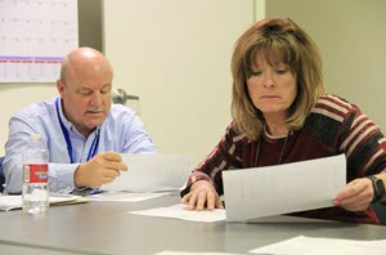 Spent Nuclear Fuel Support Manager Mark Stubblefield and Nuclear Facility Manager Pat Spaulding review maintenance logs of repairs.