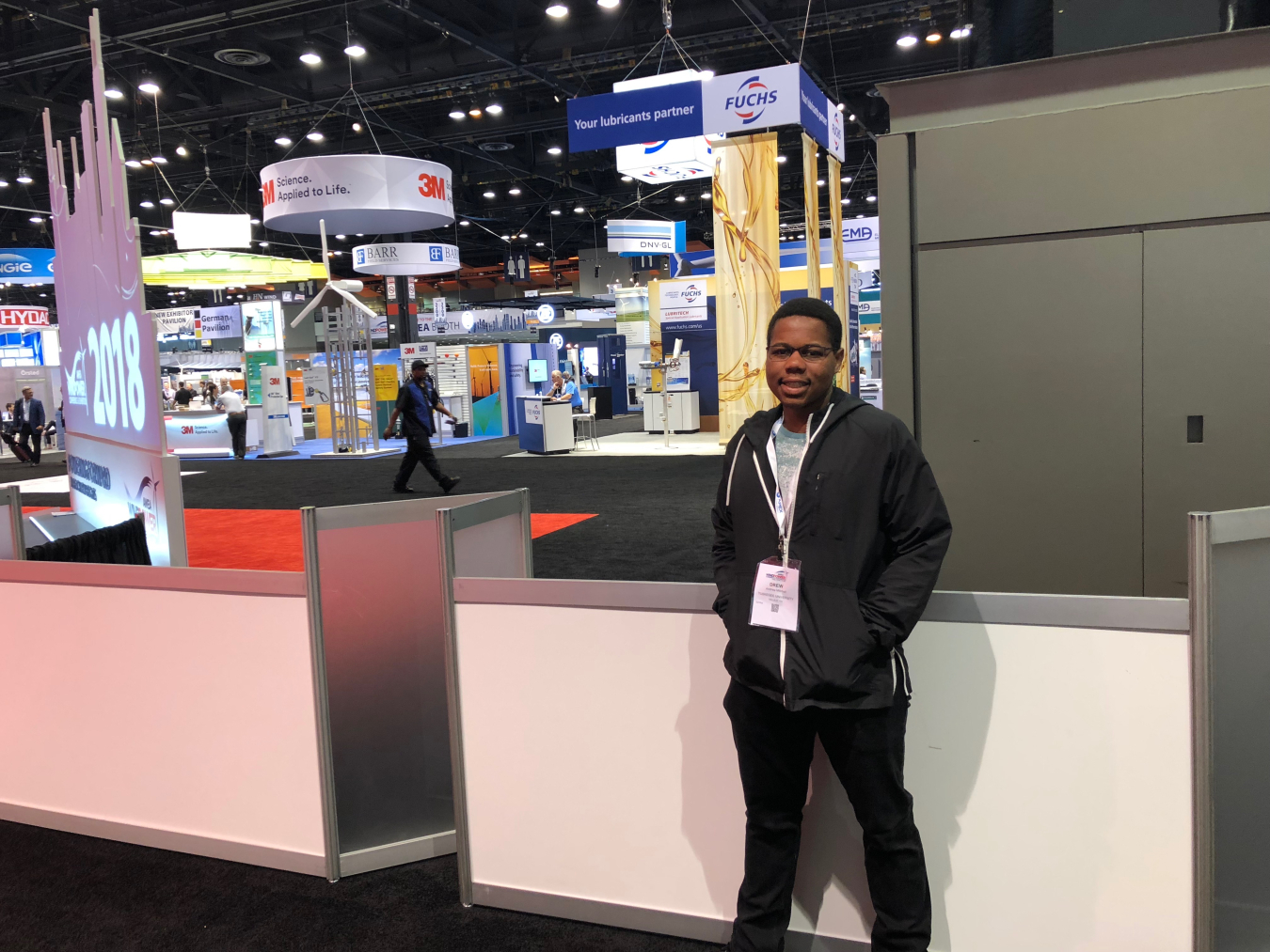 Student stands in front of industry booths at the AWEA WINDPOWER conference.