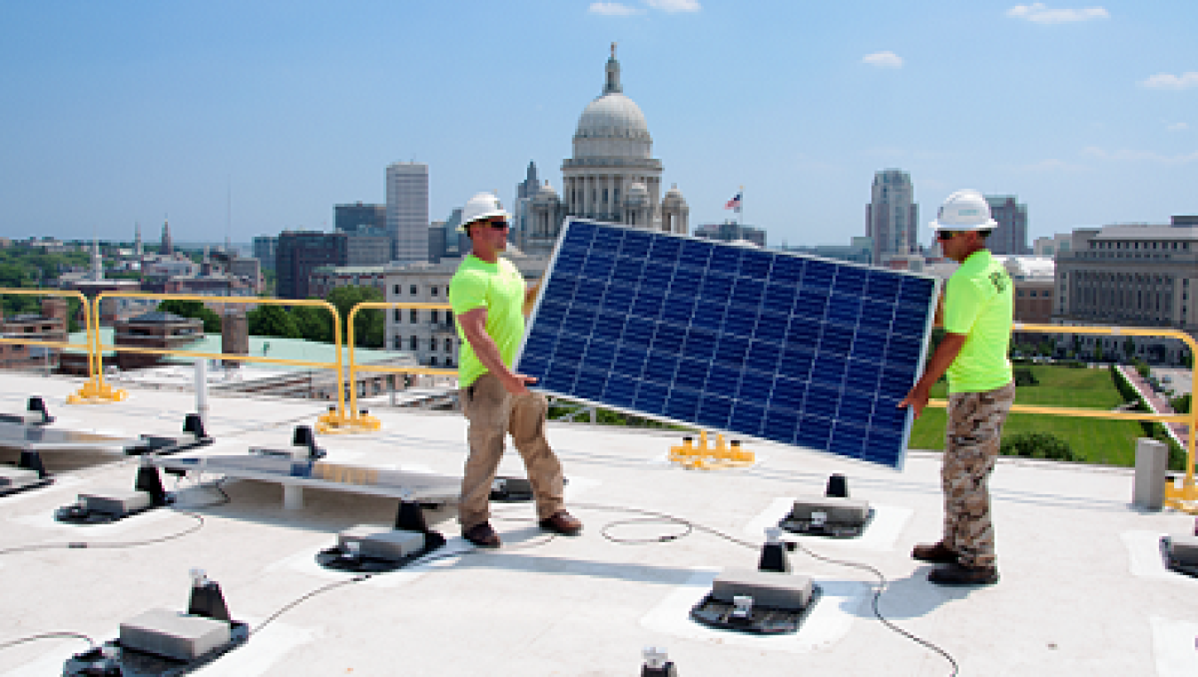 Photo of two men with solar panels.