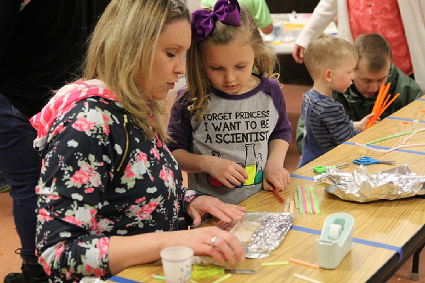 Lea Squires and her daughter Rylea fashion a container used to test Archimedes theory of water displacement.