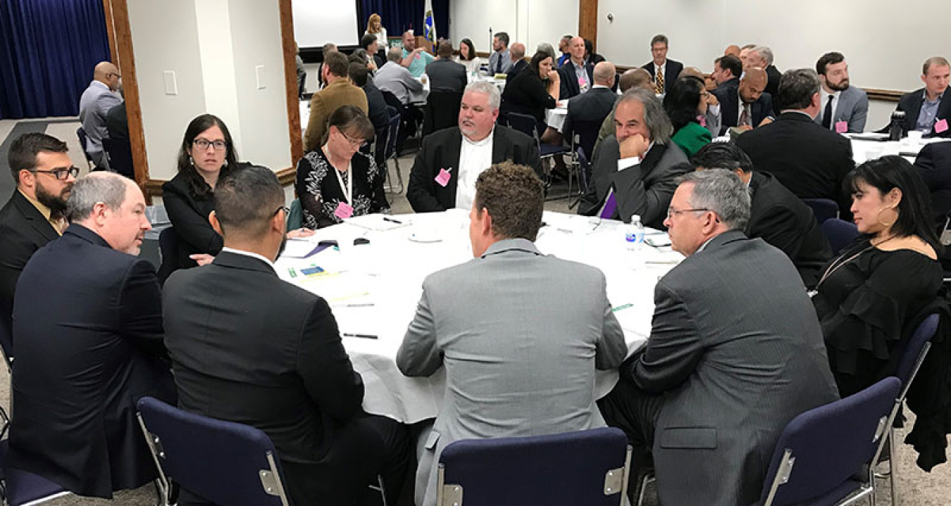 Attendees sitting around tables at the 2018 Champions Shared Lessons Learned Forum.