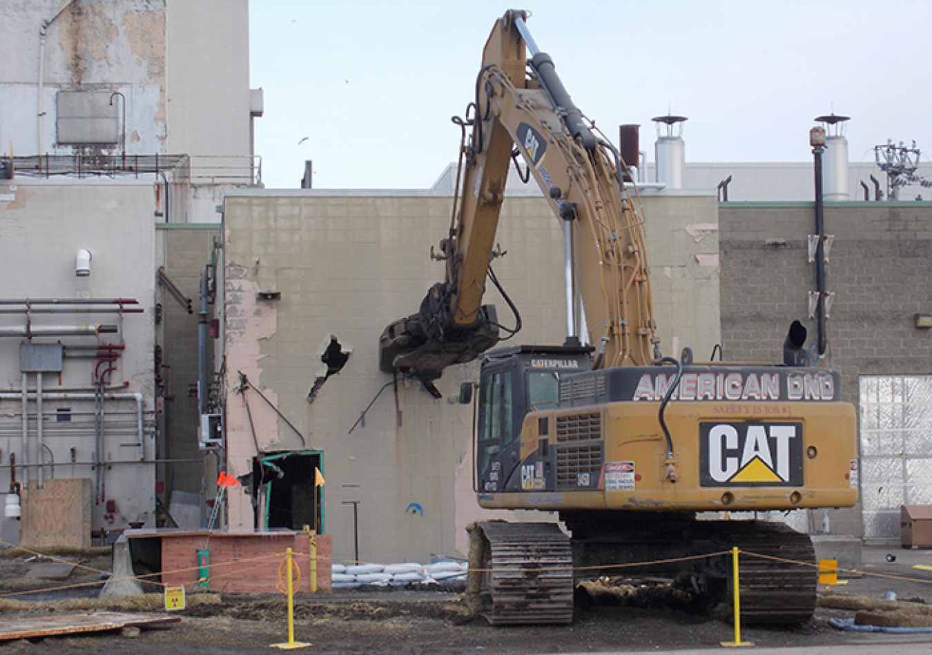 An excavator takes the “first bite” out of the laundry facility. 