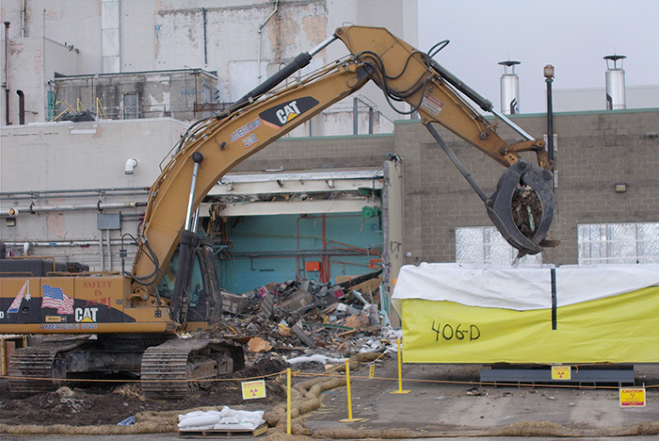 Workers load debris for off-site disposal after finishing the laundry facility demolition.