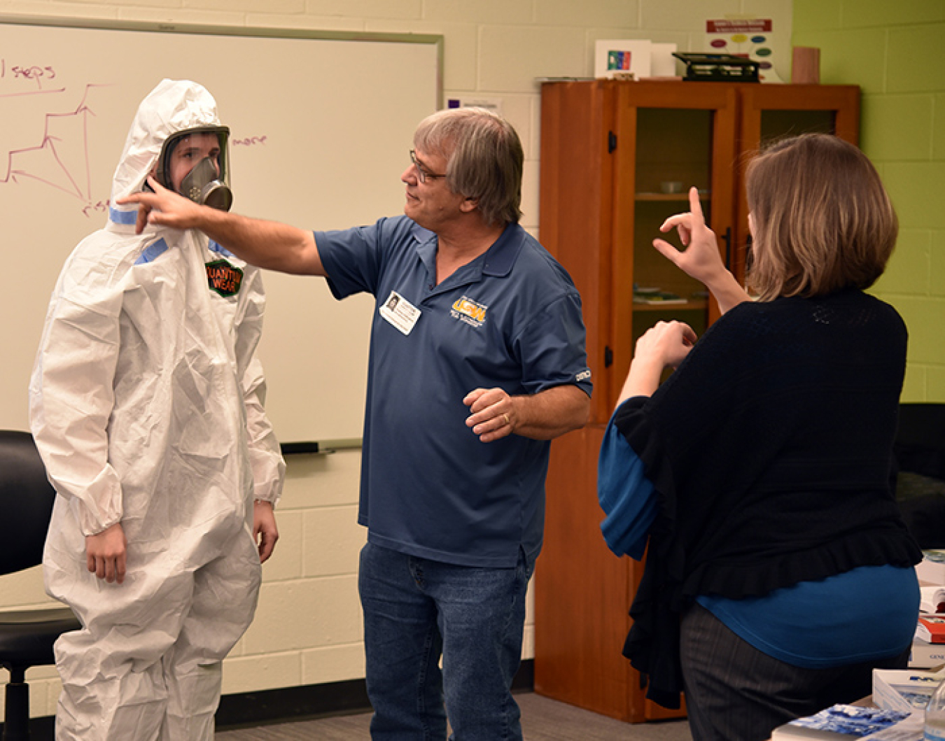 A student tries on a respirator with the help of instructor Billy Edington during the safety class.