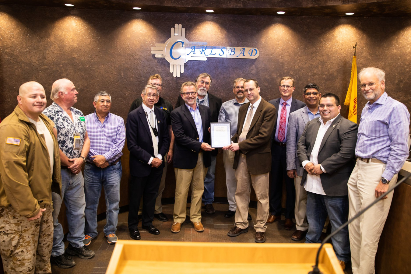 CBFO Manager Todd Shrader, center, right, and NWP President and Project Manager Bruce Covert hold a proclamation from Carlsbad Mayor Dale Janway, left of Covert, declaring March 26-April 26 as WIPP Appreciation Month.