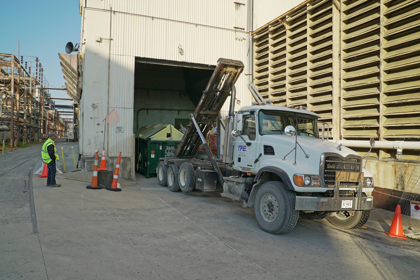 Workers relocate a debris container from the Alpha 4 heating area to the fogging demonstration area at the Oak Ridge Site.