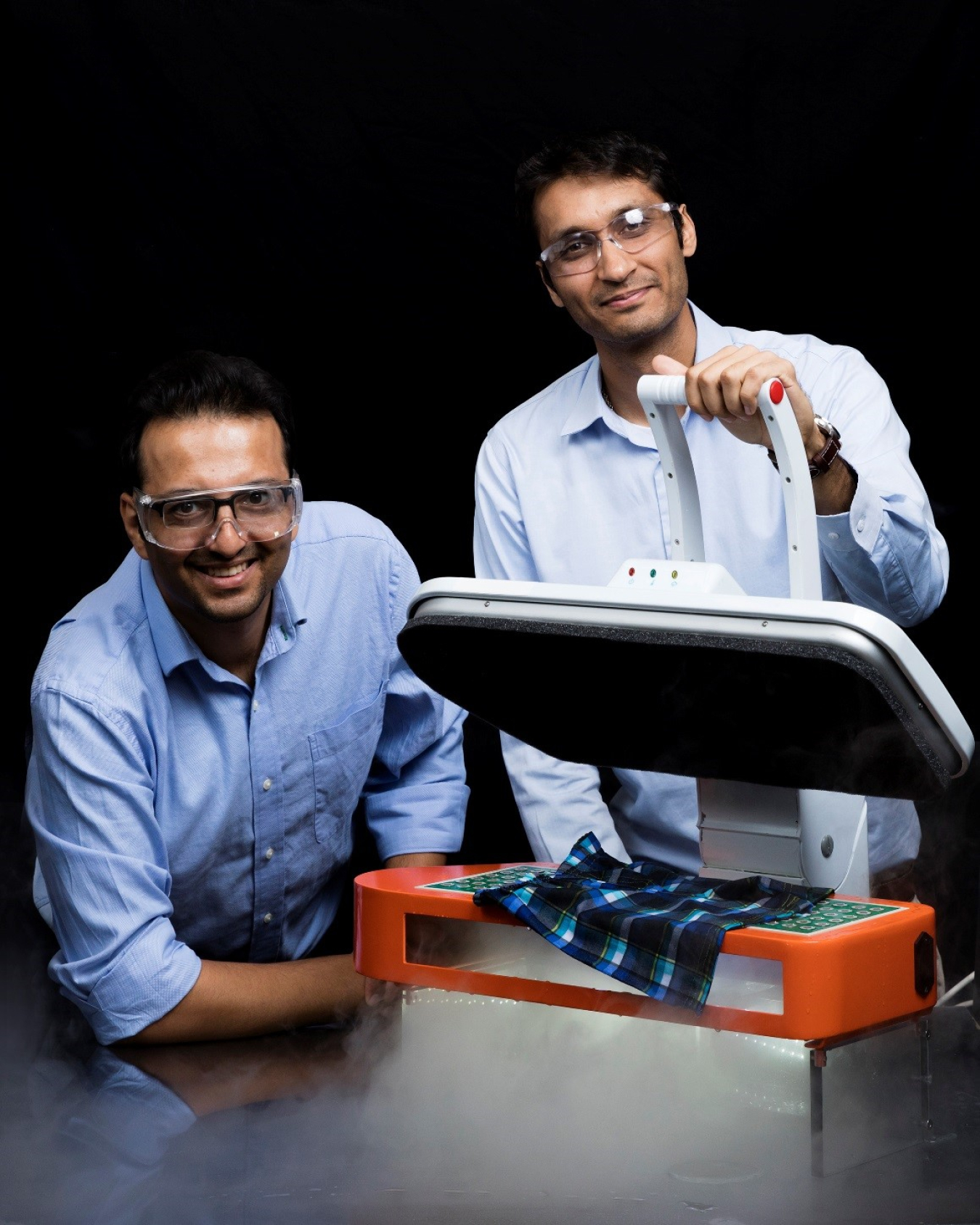 Two men posing, facing the camera, with an ultrasonic clothes dryer.