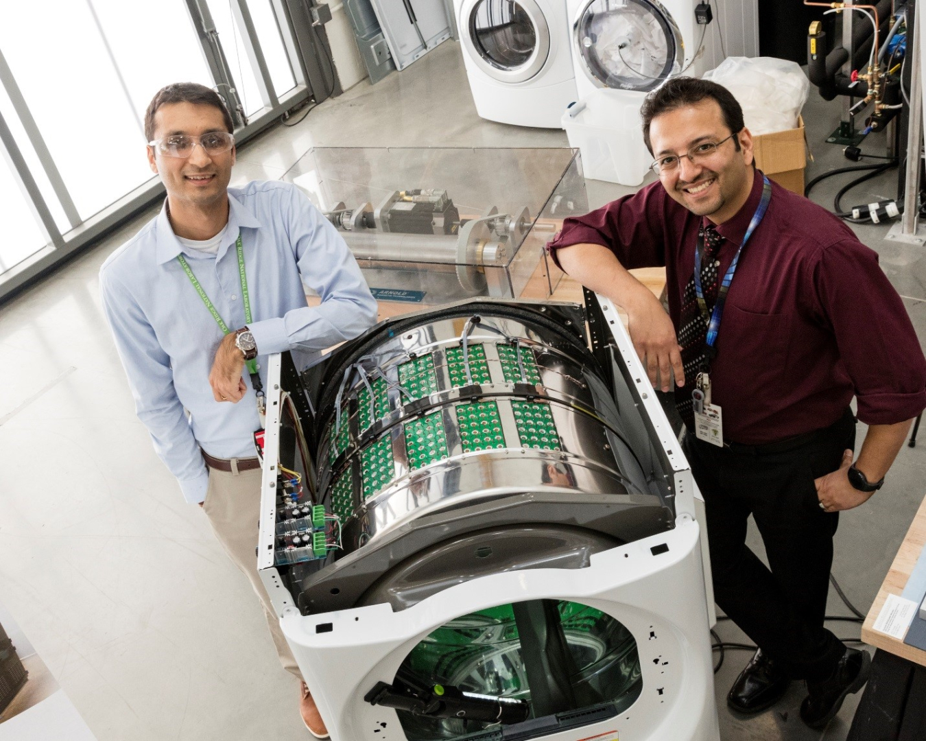 Two men posing, facing the camera, with an ultrasonic clothes dryer.