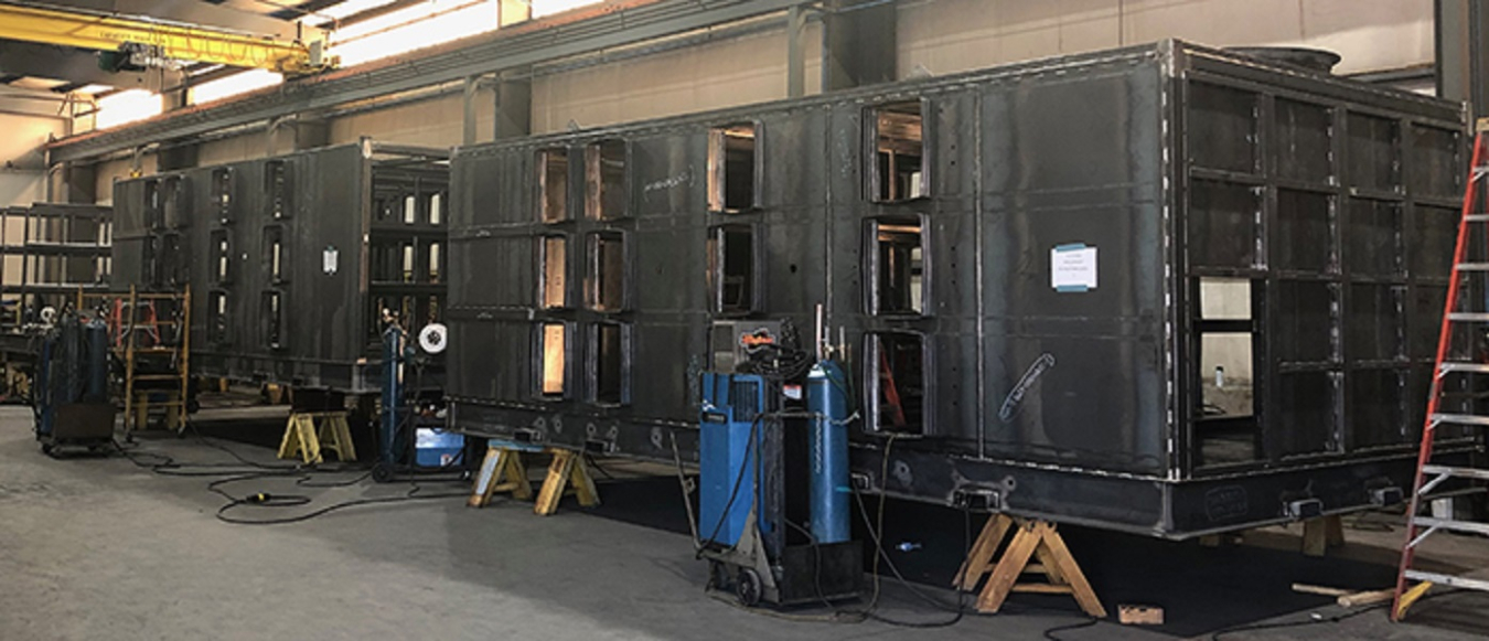 Workers have made progress on the Safety Significant Confinement Ventilation System, advancing from a 2016 illustration of the system’s capital project (at top) to the fabrication of components for the system this year.
