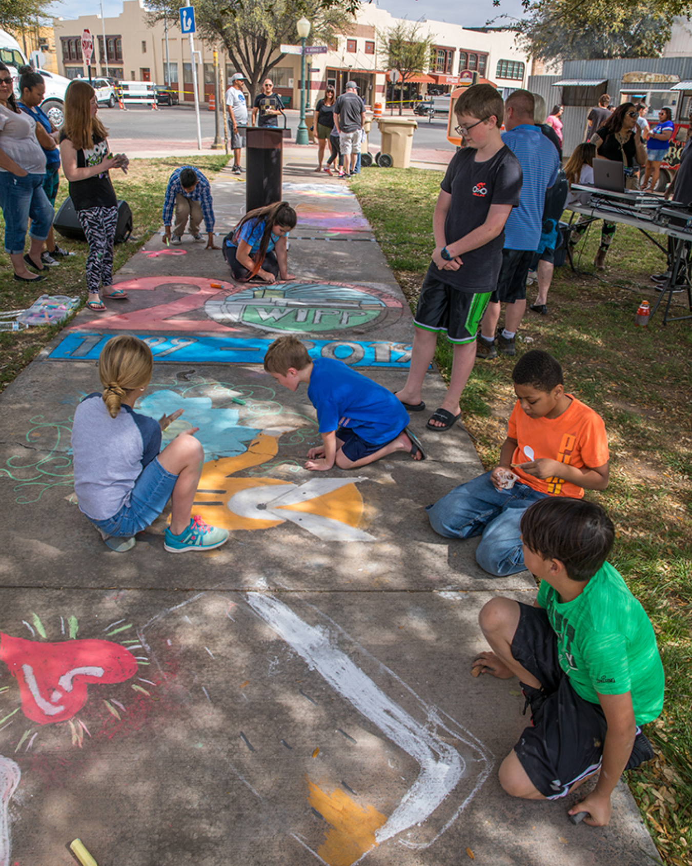 Children create sidewalk art.