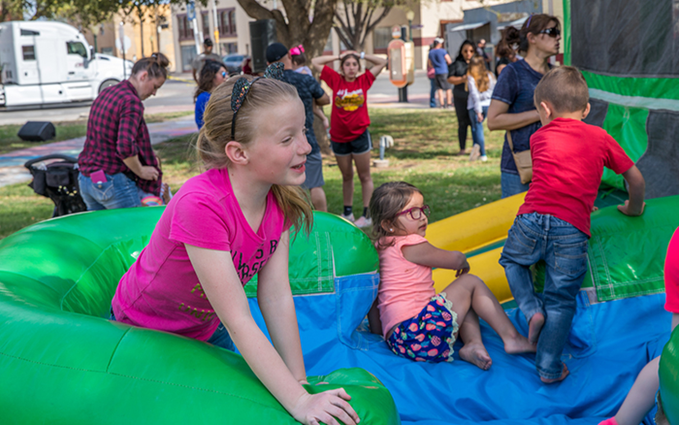 Children jump around in an inflatable playhouse as part of festivities.