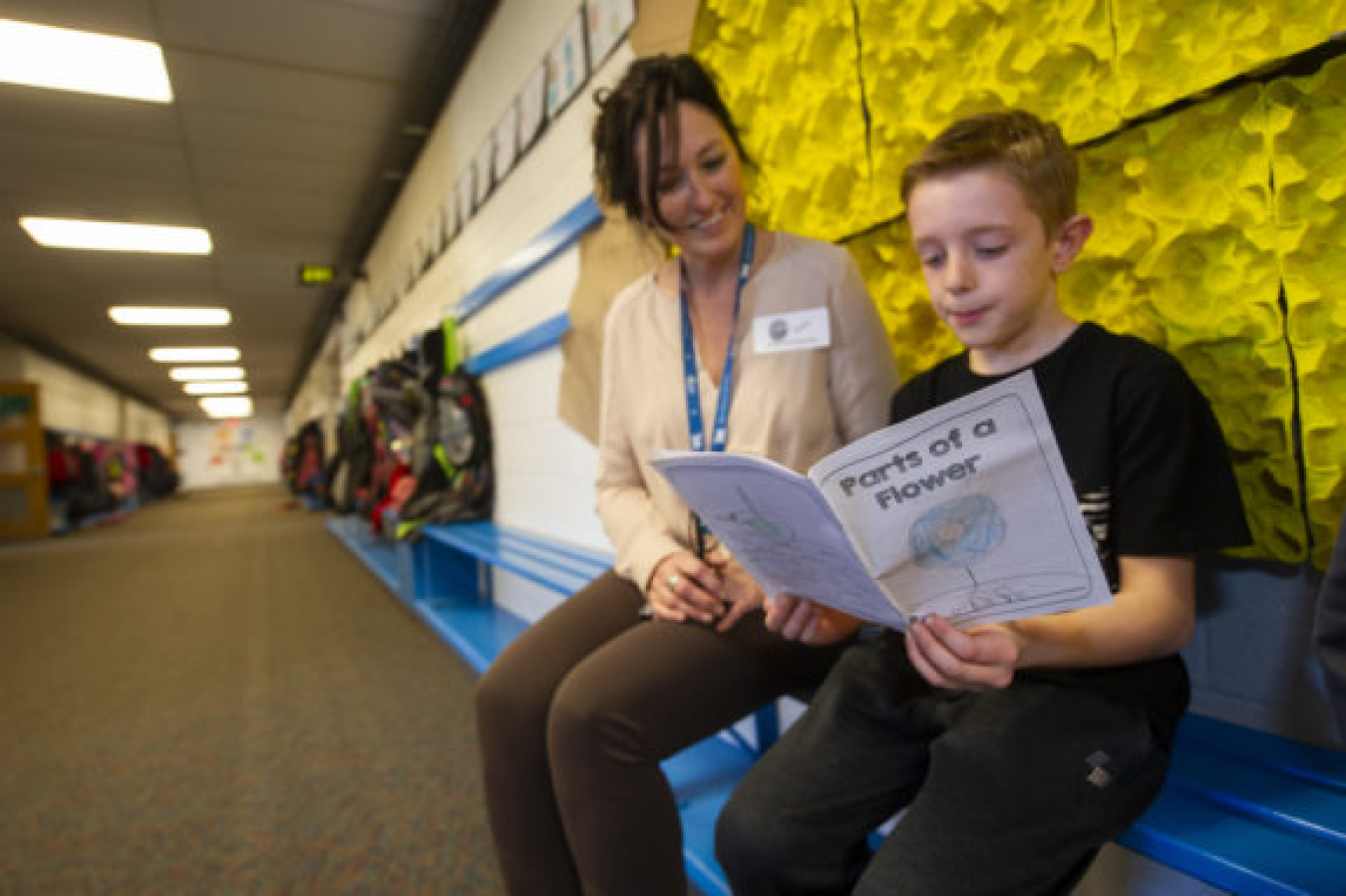 A Temple View student shows his “Parts of a Flower” journal to INL’s Jennifer Jackson.