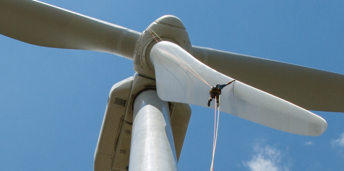 person rappelling down a wind turbine.