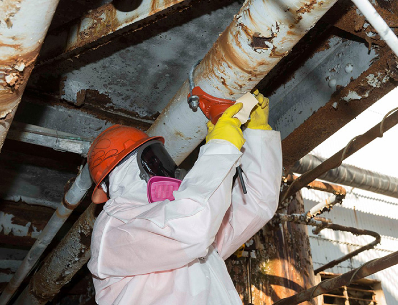 A worker installs a “hot tap,” which allows crews to connect to existing piping without spilling its contents. 