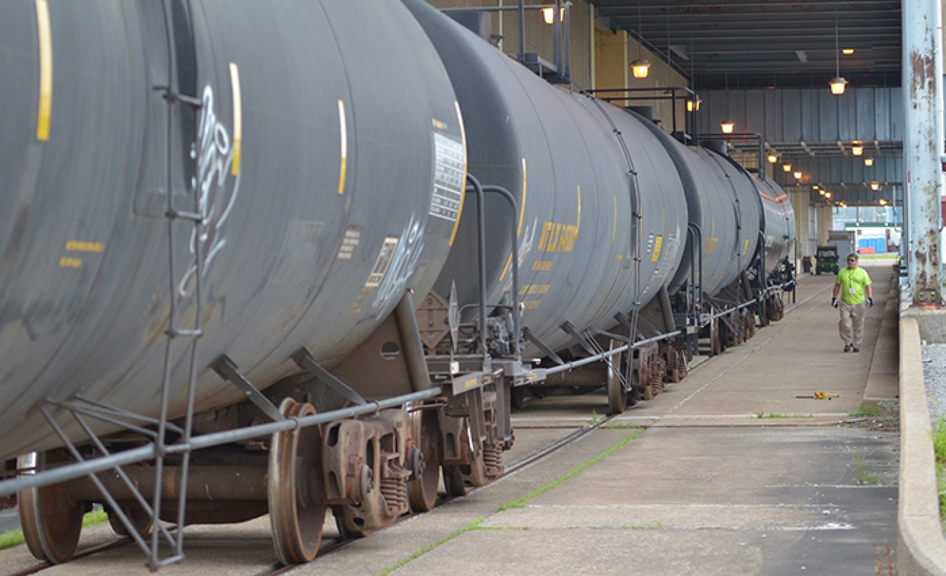 A deactivation worker inspects railcars containing insulating oil from the Paducah Site’s C-533 Switchyard as they are prepared to be shipped to a buyer for the Paducah Area Community Reuse Organization.