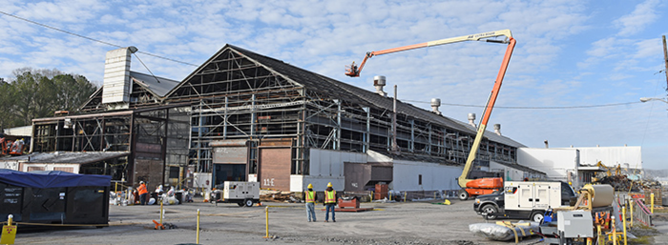 Workers take asbestos-containing panels off the K-1037 Building as the demolition project commences.