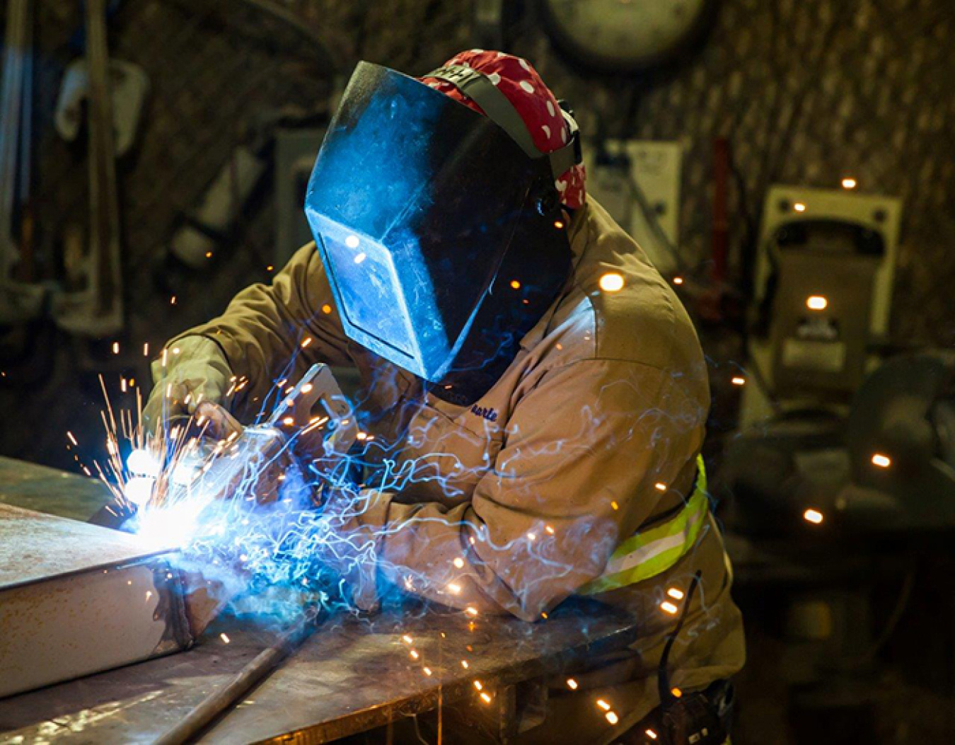 Sparks fly as Ismael Duarte welds in the Waste Isolation Pilot Plant (WIPP) underground. WIPP has several maintenance and fabrication shops carved out of an ancient salt layer.