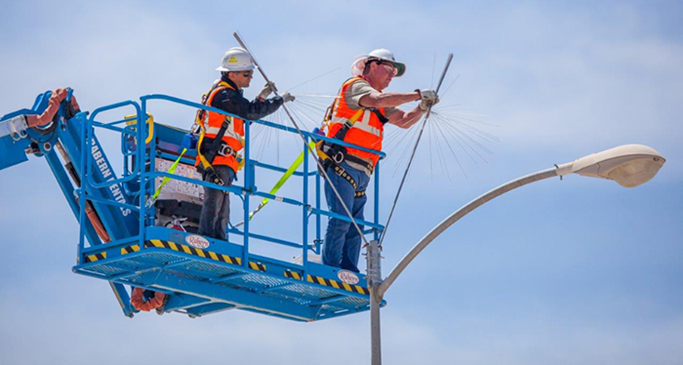 Workers install dandelion-shaped arrays atop light poles as part of upgrades to Waste Isolation Pilot Plant’s lightning protection system. The arrays fill gaps in the existing system.