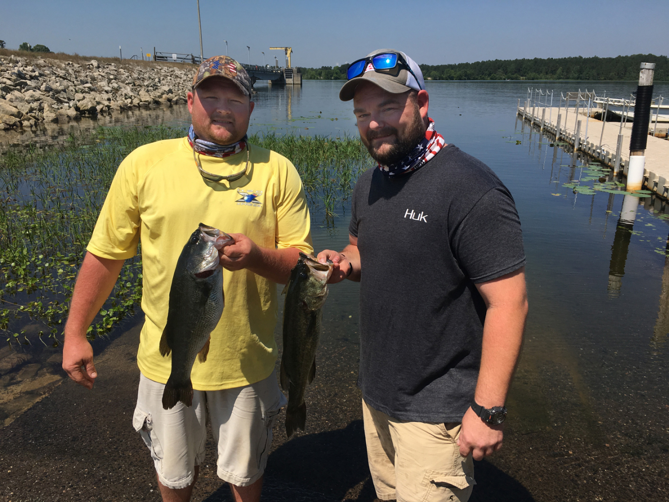 Savannah River Nuclear Solutions employee and veteran Jeffrey Lanier (right), a former Apache Helicopter Crew Chief in Afghanistan, and his brother Ronald, each hold a large bass caught during the Ultimate Fishing Challenge, recently held at SRS to honor