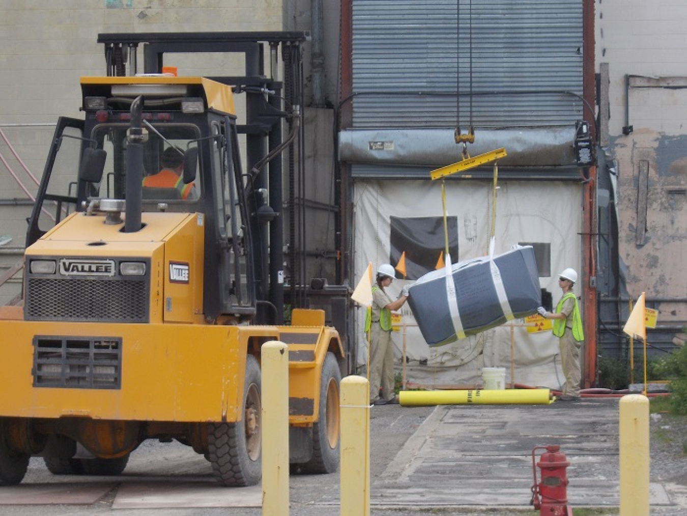 Workers remove a 900-pound lift bag of asbestos material from the Main Plant Process Building at EM’s West Valley Demonstration Project. The bag was carried out of the facility on a conveyor system created by employees at the site.